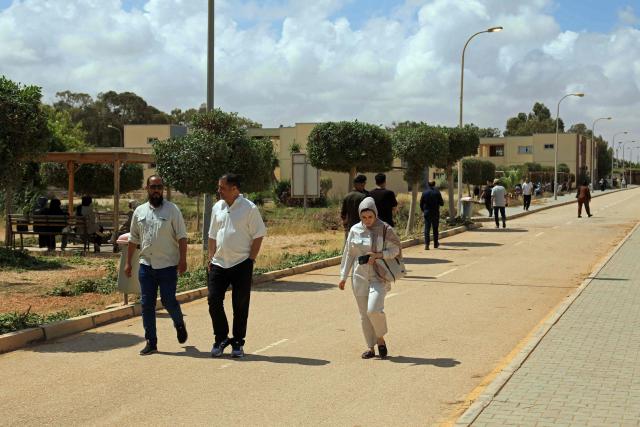 People walk inside campus of the University of Benghazi, in Benghazi on May 20, 2026. A decade after fierce battles reduced much of the University of Benghazi to rubble, students at Libya's oldest and largest university are once again looking to the future with optimism. The university, founded in 1955, had become after the 2011 uprisings that toppled and killed longtime ruler Muammar Gaddafi the stage of intense fightings between jihadist groups and forces led by military strongman Khalifa Haftar. (Photo by Abdullah DOMA / AFP) / To go with 'Libya-Youth-Development-Education', REPORTAGE by Françoise KADRI