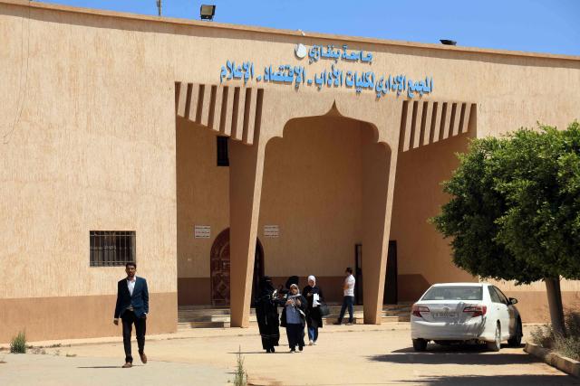 People walk inside campus of the University of Benghazi, in Benghazi on May 20, 2026. A decade after fierce battles reduced much of the University of Benghazi to rubble, students at Libya's oldest and largest university are once again looking to the future with optimism. The university, founded in 1955, had become after the 2011 uprisings that toppled and killed longtime ruler Muammar Gaddafi the stage of intense fightings between jihadist groups and forces led by military strongman Khalifa Haftar. (Photo by Abdullah DOMA / AFP) / To go with 'Libya-Youth-Development-Education', REPORTAGE by Françoise KADRI