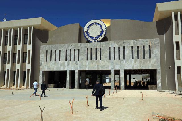 People walk inside the campus of the University of Benghazi, in Benghazi on May 20, 2026. A decade after fierce battles reduced much of the University of Benghazi to rubble, students at Libya's oldest and largest university are once again looking to the future with optimism. The university, founded in 1955, had become after the 2011 uprisings that toppled and killed longtime ruler Muammar Gaddafi the stage of intense fightings between jihadist groups and forces led by military strongman Khalifa Haftar. (Photo by Abdullah DOMA / AFP) / To go with 'Libya-Youth-Development-Education', REPORTAGE by Françoise KADRI