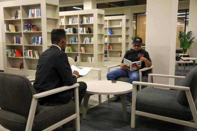People read books inside the newly renovated library at the University of Benghazi, in Benghazi on May 20, 2026. A decade after fierce battles reduced much of the University of Benghazi to rubble, students at Libya's oldest and largest university are once again looking to the future with optimism. The university, founded in 1955, had become after the 2011 uprisings that toppled and killed longtime ruler Muammar Gaddafi the stage of intense fightings between jihadist groups and forces led by military strongman Khalifa Haftar. (Photo by Abdullah DOMA / AFP) / To go with 'Libya-Youth-Development-Education', REPORTAGE by Françoise KADRI