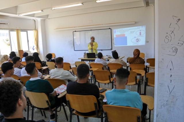 Students attend a lecture at the University of Benghazi, in Benghazi on May 20, 2026. A decade after fierce battles reduced much of the University of Benghazi to rubble, students at Libya's oldest and largest university are once again looking to the future with optimism. The university, founded in 1955, had become after the 2011 uprisings that toppled and killed longtime ruler Muammar Gaddafi the stage of intense fightings between jihadist groups and forces led by military strongman Khalifa Haftar. (Photo by Abdullah DOMA / AFP) / To go with 'Libya-Youth-Development-Education', REPORTAGE by Françoise KADRI
