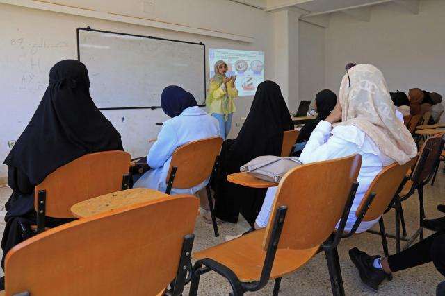 Students attend a lecture at the University of Benghazi, in Benghazi on May 20, 2026. A decade after fierce battles reduced much of the University of Benghazi to rubble, students at Libya's oldest and largest university are once again looking to the future with optimism. The university, founded in 1955, had become after the 2011 uprisings that toppled and killed longtime ruler Muammar Gaddafi the stage of intense fightings between jihadist groups and forces led by military strongman Khalifa Haftar. (Photo by Abdullah DOMA / AFP) / To go with 'Libya-Youth-Development-Education', REPORTAGE by Françoise KADRI