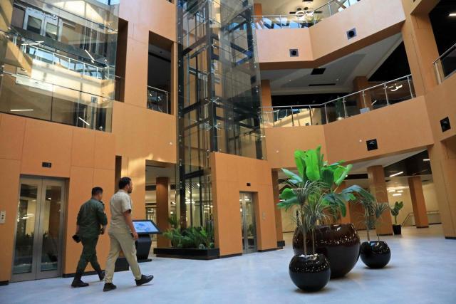 People walk inside a building of the University of Benghazi, in Benghazi on May 20, 2026. A decade after fierce battles reduced much of the University of Benghazi to rubble, students at Libya's oldest and largest university are once again looking to the future with optimism. The university, founded in 1955, had become after the 2011 uprisings that toppled and killed longtime ruler Muammar Gaddafi the stage of intense fightings between jihadist groups and forces led by military strongman Khalifa Haftar. (Photo by Abdullah DOMA / AFP) / To go with 'Libya-Youth-Development-Education', REPORTAGE by Françoise KADRI