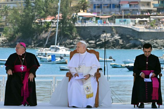 Pope Leo XIV sits flanked by the bishop of the diocese of Canarias, Jose Mazuelos (L) and his persoal secretary Edgard Rimaycuna (R), during a meeting with organizations working with migrants in the port of Arguineguin on the Canary Island of Gran Canaria, a place accustomed to the arrival of migrants, on June 11, 2026. Pope Leo XIV is visiting Spain June 6-12 with stops in Madrid, Barcelona, and the Canary Islands, where he will meet with migrants and organisations dedicated to helping them. (Photo by Stefano RELLANDINI / AFP)