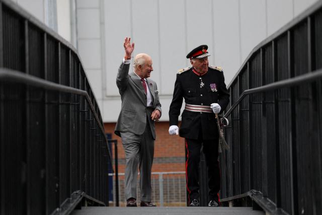 Britain's King Charles III (L) waves as he arrives at the Horizon Youth Zone, a new centre aimed at providing a safe and inspiring place for young people and offering multiple activities including sports, cooking, creative and performing arts, in the city of Grimsby, north-east England, on June 11, 2026. (Photo by Temilade Adelaja / POOL / AFP)