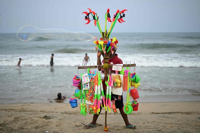 A toy vendor blowing bubbles waits for customers at Edward Elliot's beach in Chennai on June 11, 2026. (Photo by R. Satish BABU / AFP)
