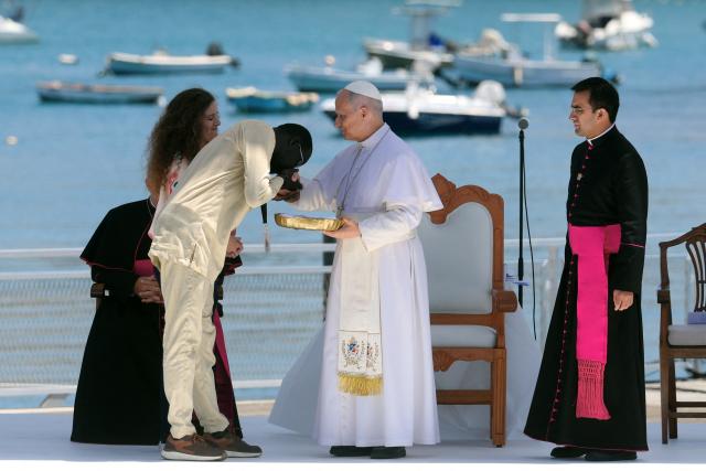 An African migrant kisses Pope Leo XIV's hand during a meeting with organizations working with migrants in the port of Arguineguin on the Canary Island of Gran Canaria, a place accustomed to the arrival of migrants, on June 11, 2026. Pope Leo XIV is visiting Spain June 6-12 with stops in Madrid, Barcelona, and the Canary Islands, where he will meet with migrants and organisations dedicated to helping them. (Photo by Pierre-Philippe MARCOU / AFP)