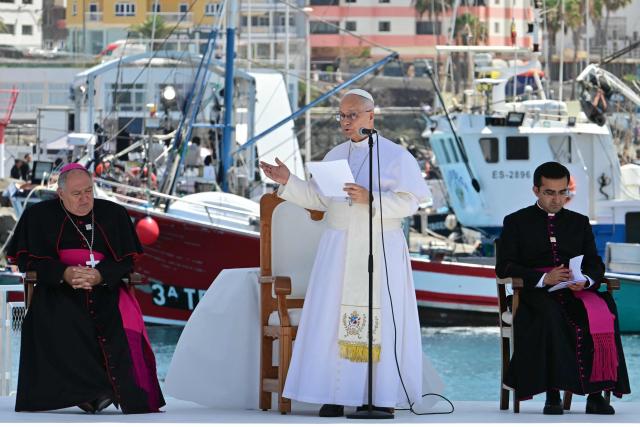 Pope Leo XIV delivers a speech flanked by the bishop of the diocese of Canarias, Jose Mazuelos (L) and his persoal secretary Edgard Rimaycuna (R), during a meeting with organizations working with migrants in the port of Arguineguin on the Canary Island of Gran Canaria, a place accustomed to the arrival of migrants, on June 11, 2026. Pope Leo XIV is visiting Spain June 6-12 with stops in Madrid, Barcelona, and the Canary Islands, where he will meet with migrants and organisations dedicated to helping them. (Photo by Stefano RELLANDINI / AFP)