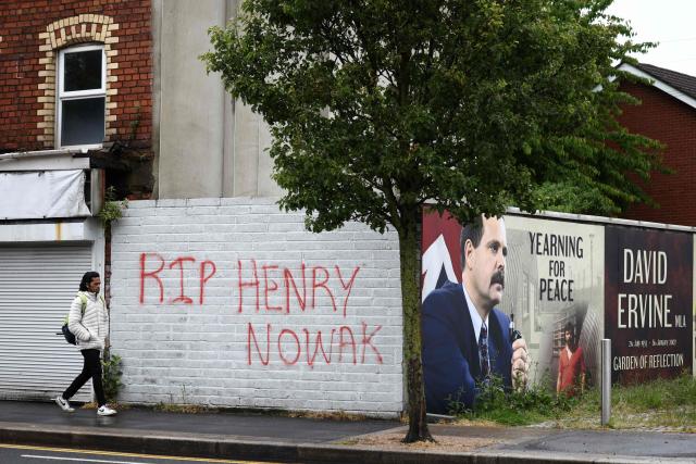 Pedestrians walk past graffiti in remembrance of stabbing victim Henry Nowak, killed in Southampton in December 2025, in Newtownards, east of Belfast, Northern Ireland, on June 11, 2026, following two consecutive nights of violence following the June 8 stabbing of Stephen Ogilvie, that triggered the unrest. Police arrested 16 people during a second night of disorder in Northern Ireland sparked by a brutal Belfast stabbing, a senior minister said Thursday, condemning rioters for "racist thuggery". (Photo by Henry NICHOLLS / AFP)