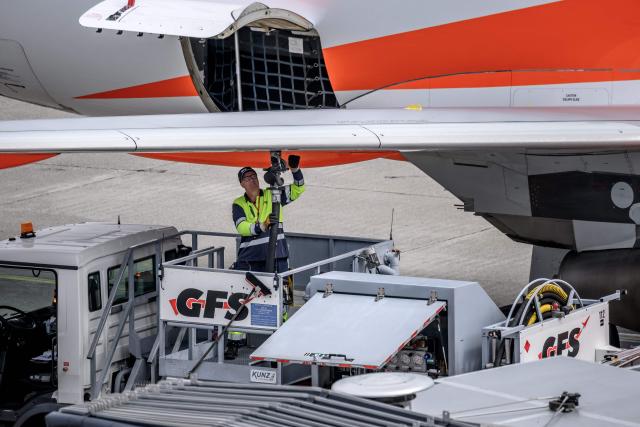 An employee of Geneva Fuelling Services (GFS) refuels an aircraft operated by British low-cost airline EasyJet at Geneva Airport on June 11, 2026. The war in the Middle East and the closure of the Strait of Hormuz have caused a surge in aviation fuel prices and raised concerns about potential shortages this summer. (Photo by Fabrice COFFRINI / AFP)