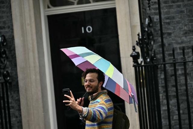 A person takes a selfie photograph outside the door to 10 Downing Street, the official residence of Britain's Prime Minister, in central London on June 11, 2026. (Photo by Ben STANSALL / AFP)