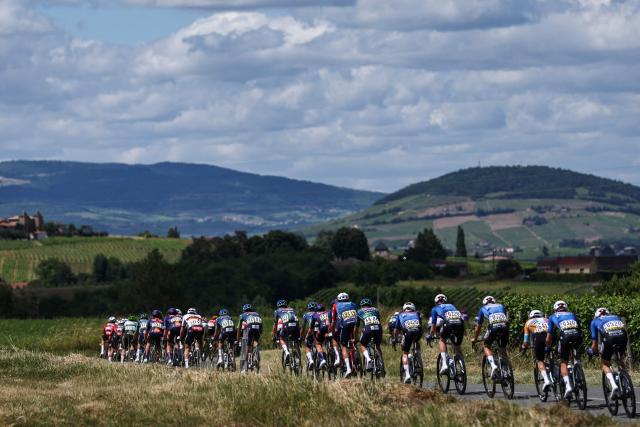 The pack of riders cycles during the 5th stage of the Tour Auvergne-Rhone-Alpes cycling race (formerly known as the Criterium du Dauphine), 195,8km between Saint-Chamond and Villars-les-Dombes, central France, on June 11, 2026. (Photo by Anne-Christine POUJOULAT / AFP)