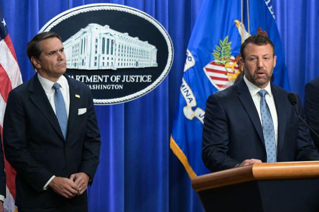 (L/R) US Acting Attorney General Todd Blanche looks on as Secretary of Homeland Security Markwayne Mullin speaks during a press conference about safeguarding unaccompanied immigrant children at the Department of Justice headquarters in Washington, DC, on June 11, 2026. (Photo by Oliver Contreras / AFP)