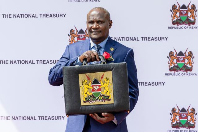 Kenya's National Treasury and Economic Planning Cabinet Secretary John Mbadi holds the 'budget briefcase' in the famed pose outside his office at the Treasury as he proceeds to the Parliament building to read the 2026-2027 financial year national budget in Nairobi on June 11, 2026. (Photo by Tony KARUMBA / AFP)