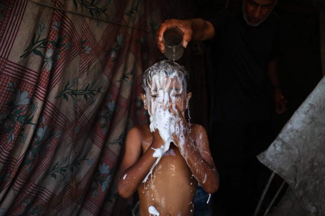 A Palestinian boy washes himself in a makeshift shelter at Gaza’s Nuseirat refugee camp on June 11, 2026. Discussions between Palestinian factions and mediators in Cairo aimed at reaching a permanent end to the war in Gaza have stalled over the pivotal question of disarming the territory and Hamas, Palestinian sources told AFP on June 9. (Photo by Eyad Baba / AFP)