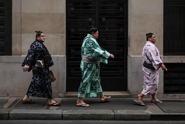 TOPSHOT - Sumo wrestlers walk in a street of Paris on June 11, 2026. Paris is holding on June 13 and 14, 2026 the Paris Sumo Tournament. (Photo by SIMON WOHLFAHRT / AFP)