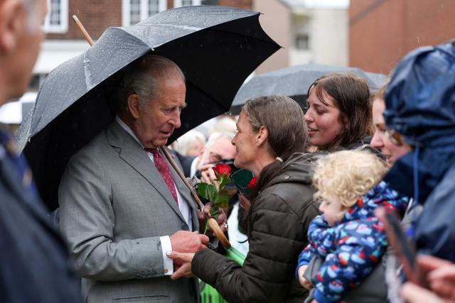 Britain's King Charles III greets well-wishers who had waited in the rain in the hope of meeting him, during his visit to Grimsby, north-east England, on June 11, 2026. (Photo by Temilade Adelaja / POOL / AFP)