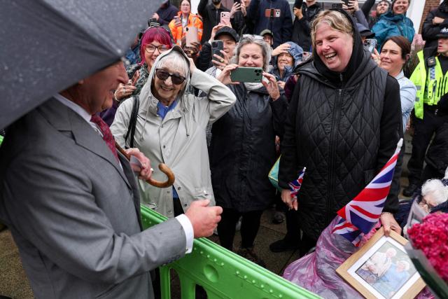 Britain's King Charles III greets well-wishers who had waited in the rain in the hope of meeting him, during his visit to Grimsby, north-east England, on June 11, 2026. (Photo by Temilade Adelaja / POOL / AFP)