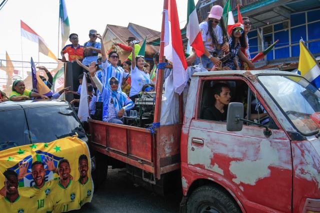 Football fans participate in a convoy welcoming the 2026 FIFA World Cup tournament on the eve of its start in Polewali Mandar in Indonesia's West Sulawesi on June 11, 2026. (Photo by Muhammad SALIM / AFP)