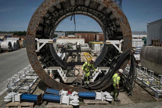 Engineers work on a tunnel-digging machine during a media tour of BESSAC, a company specializing in the construction of tunnels and micro-tunnels, at their plant in Saint-Jory, near Toulouse, southwestern France on June 11, 2026. (Photo by Ed JONES / AFP)