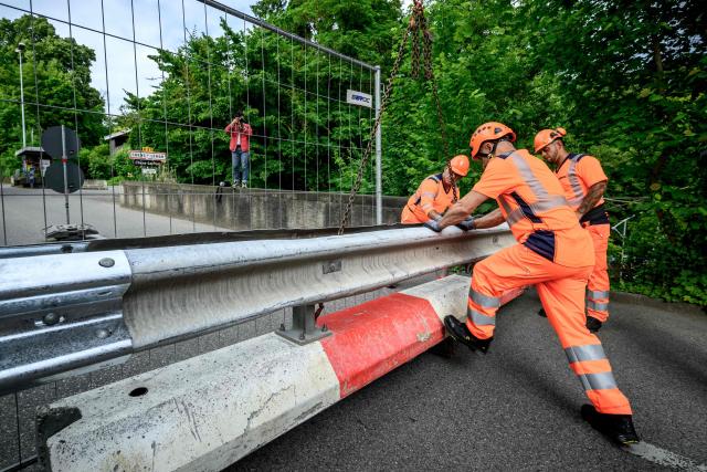 Workers install a baracade to close the border crossing between Hermance in Switzerland and Chens sur Leman in France, ahead of the upcoming G7 summit in nearby Evian, in Hermance, on June 11, 2026. The closure of 21 of the 28 border crossings between the canton of Geneva and France ahead of the G7 summit is creating a headache for cross-border commuters. (Photo by Fabrice COFFRINI / AFP)
