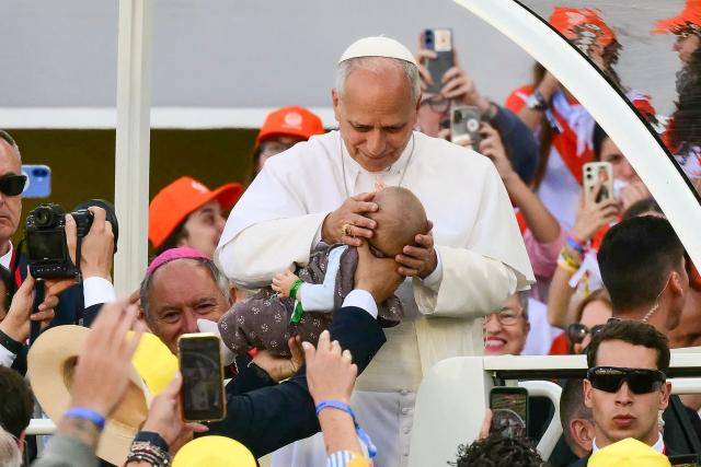Pope Leo XIV blesses a baby as he enters the Gran Canaria Stadium to lead a Holy mass in Las Palmas on the island of Gran Canaria, in Spain's Canary Islands, a place accustomed to the arrival of migrants, on June 11, 2026. Pope Leo XIV is visiting Spain June 6-12 with stops in Madrid, Barcelona, and the Canary Islands, where he will meet with migrants and organisations dedicated to helping them. (Photo by Stefano RELLANDINI / AFP)