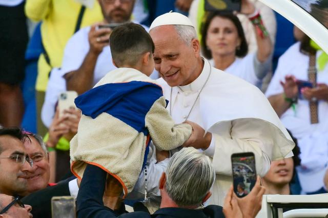 Pope Leo XIV greets a child as he enters the Gran Canaria Stadium to lead a Holy mass in Las Palmas on the island of Gran Canaria, in Spain's Canary Islands, a place accustomed to the arrival of migrants, on June 11, 2026. Pope Leo XIV is visiting Spain June 6-12 with stops in Madrid, Barcelona, and the Canary Islands, where he will meet with migrants and organisations dedicated to helping them. (Photo by Stefano RELLANDINI / AFP)