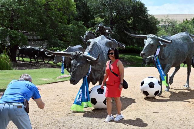 Tourists take pictures at the cattle drive sculpture by artist Robert Summers, during the FIFA 2026 world cup at Pioneer Plaza in Dallas, Texas on June 11, 2026. (Photo by Paul ELLIS / AFP)