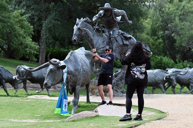 Tourists take pictures at the cattle drive sculpture by artist Robert Summers, during the FIFA 2026 world cup at Pioneer Plaza in Dallas, Texas on June 11, 2026. (Photo by Paul ELLIS / AFP)