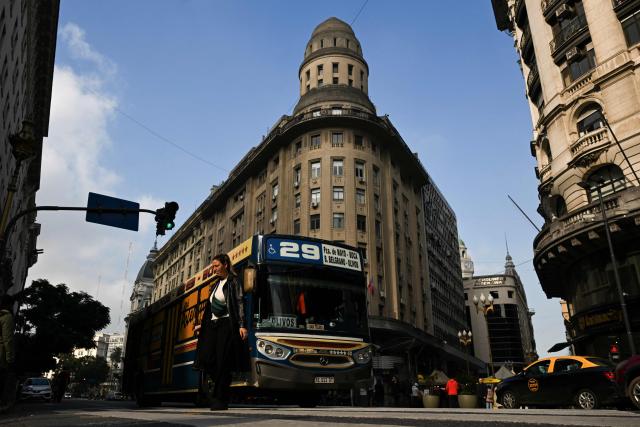 A woman crosses a street amid traffic in Buenos Aires on June 11, 2026. (Photo by Luis ROBAYO / AFP)