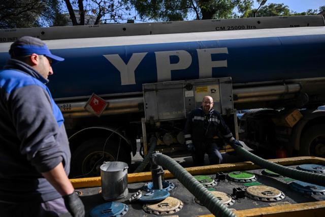 Workers unload fuel from a tanker truck at a gas station in Buenos Aires on June 11, 2026. (Photo by Luis ROBAYO / AFP)