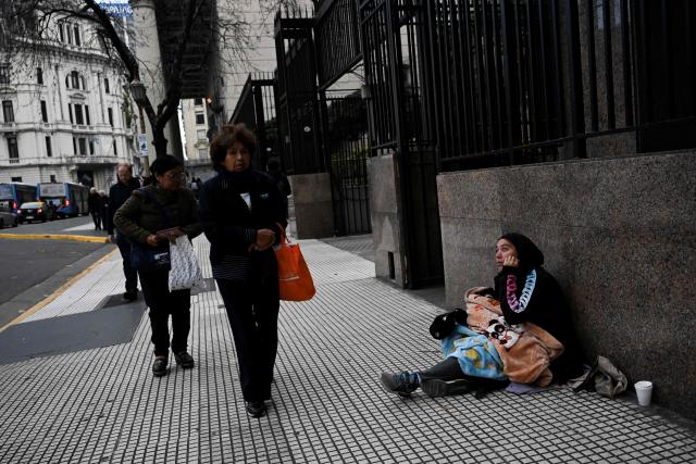 A woman begs for money in downtown Buenos Aires on June 11, 2026. (Photo by Luis ROBAYO / AFP)