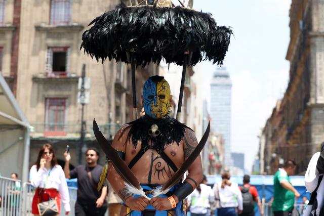 A Mexican fan dressed in an Aztec-style warrior costume poses at the FIFA Fan Festival at Zocalo square in Mexico City on June 11, 2026, ahead of the World Cup football tournament Group A match between Mexico and South Africa. (Photo by LUIS CORTES / AFP)