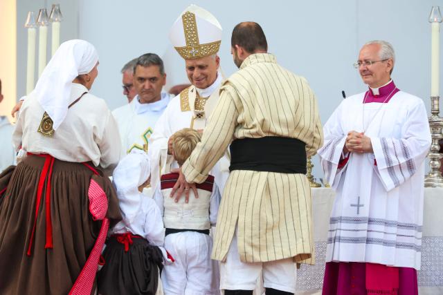 Pope Leo XIV receives people in traditional dress while leading a Holy mass at the Gran Canaria Stadium in Las Palmas on the Canary Island of Gran Canaria, a place accustomed to the arrival of migrants, on June 11, 2026. Pope Leo XIV is visiting Spain June 6-12 with stops in Madrid, Barcelona, and the Canary Islands, where he will meet with migrants and organisations dedicated to helping them. (Photo by Pierre-Philippe MARCOU / AFP)