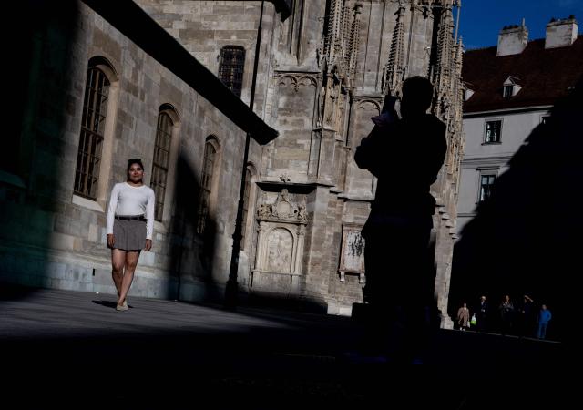 A couple take some pictures outside of Saint Stephen’s cathedral during the late afternoon light, in Vienna, on June 11, 2026. (Photo by Joe Klamar / AFP)
