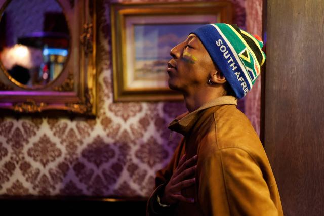 A South African football supporter reacts during the national anthem as he watches the live broadcast of the opening football match of the 2026 FIFA World Cup between Mexico and South Africa, at Kitcheners in Braamfontein, in Johannesburg, on June 11, 2026. (Photo by WIKUS DE WET / AFP)