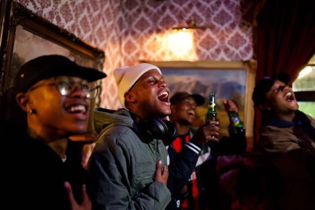 South African football supporters sing the national anthem during the national anthem as they watch the live broadcast of the opening football match of the 2026 FIFA World Cup between Mexico and South Africa, at Kitcheners in Braamfontein, in Johannesburg, on June 11, 2026. (Photo by WIKUS DE WET / AFP)