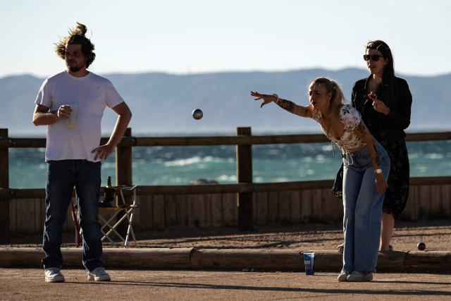 People play French bowls, also known as petanque, near the Pointe Rouge beach, south of Marseille, southern France on June 11,2026. (Photo by MIGUEL MEDINA / AFP)
