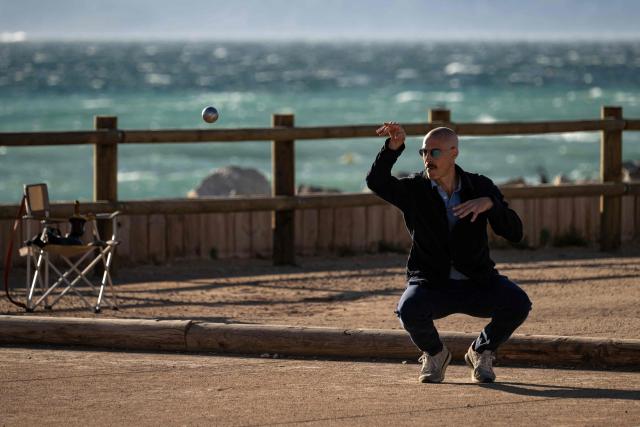 People play French bowls, also known as petanque, near the Pointe Rouge beach, south of Marseille, southern France on June 11,2026. (Photo by MIGUEL MEDINA / AFP)