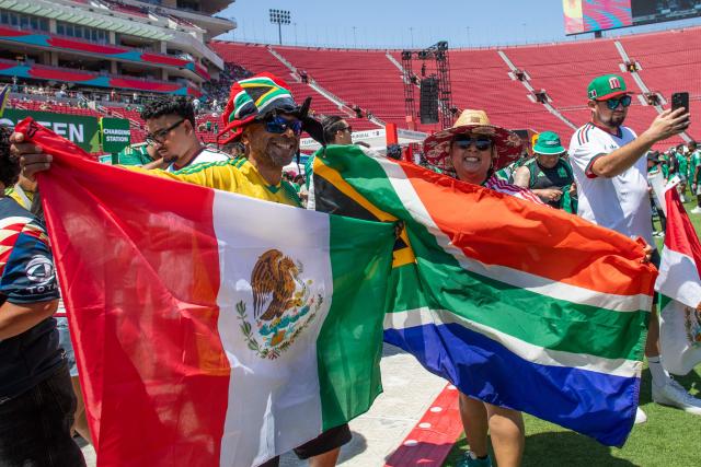Mexico and South Afria fans wave flags during the FIFA Fan Festival as they gather to watch the match between Mexico and South Africa on opening day of the 2026 World Cup football tournament at the LA Memorial Coliseum in Los Angeles on June 11, 2026. Mexico and South Africa are opening the 2026 World Cup football tournament Group A, in Mexico City. (Photo by Apu GOMES / AFP)