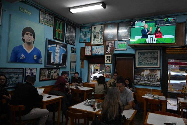 Diners sit at El Cuartito restaurant as the opening ceremony of the 2026 FIFA World Cup is shown on a television screen in Buenos Aires on June 11, 2026. (Photo by Luis ROBAYO / AFP)