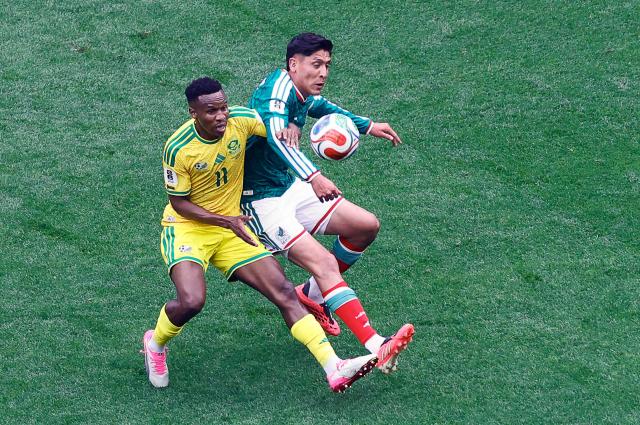South Africa's midfielder #11 Themba Zwane and Mexico's midfielder #04 Edson Alvarez fight for the ball during the 2026 World Cup Group A football match between Mexico and South Africa at the Mexico City Stadium in Mexico City on June 11, 2026. (Photo by Rodrigo OROPEZA / AFP)