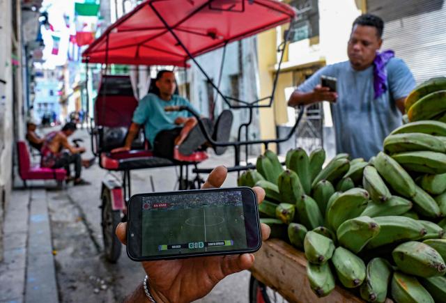 Cuban fans of Mexico's national football team watch the World Cup opening match between Mexico and South Africa on their mobile phones in Havana on June 11, 2026. (Photo by YAMIL LAGE / AFP)