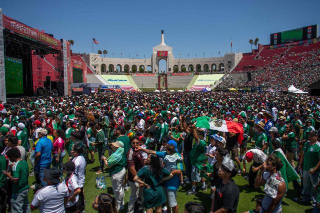 Mexico fans celebrate victory as they watch the Mexico and South Africa match on opening day of the 2026 World Cup football tournament during the FIFA Fan Festival at the LA Memorial Coliseum in Los Angeles on June 11, 2026. Mexico ignited their World Cup party with a dominant 2-0 victory over nine-man South Africa on Thursday as the biggest ever edition of the global footballing showpiece kicked off at the iconic Estadio Azteca. (Photo by Apu GOMES / AFP)