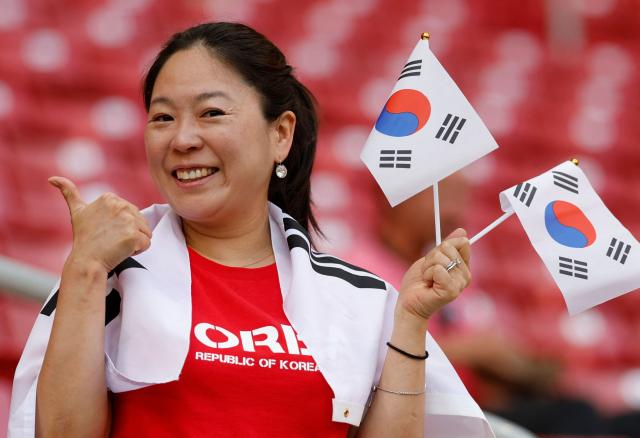 A fan of South Korea gestures as she holds national flags ahead of the 2026 World Cup Group A football match between South Korea and the Czech Republic at the Guadalajara Stadium in Zapopan on June 11, 2026. (Photo by Ulises RUIZ / AFP)