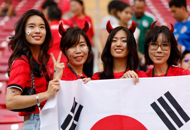 Fans of South Korea pose for a picture holding a national flag ahead of the 2026 World Cup Group A football match between South Korea and the Czech Republic at the Guadalajara Stadium in Zapopan on June 11, 2026. (Photo by Ulises RUIZ / AFP)