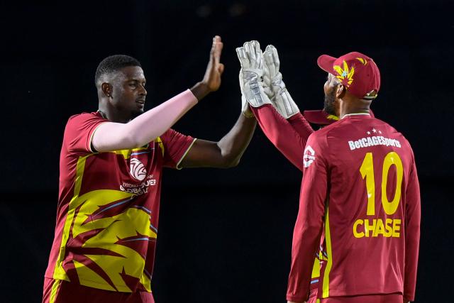 Jason Holder (L) of West Indies celebrates the dismissal of unseen Pathum Nissanka of Sri Lanka with teammates during the first Twenty20 (T20) international cricket match between West Indies and Sri Lanka at Sabina Park in Kingston, Jamaica, on June 11, 2026. (Photo by Randy Brooks / AFP)