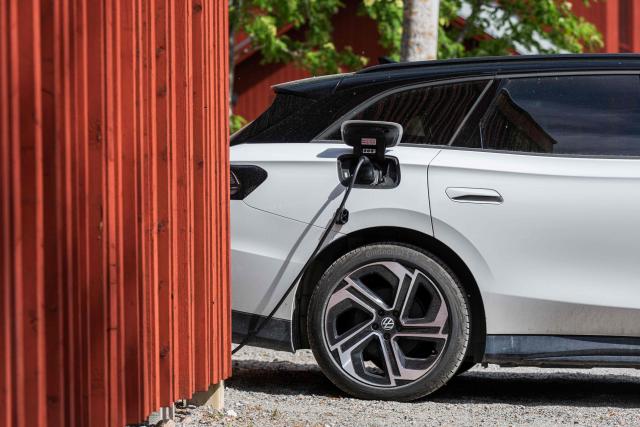 A Volkswagen electric vehicle charges at the BRF Stenberg condominium association on May 28, 2026, in Hudiksvall, Sweden. The residential pilot project uses Vehicle-to-Grid (V2G) technology, enabling electric vehicles to act as mobile energy storage units capable of supplying electricity back to the local grid when needed. (Photo by Jonathan NACKSTRAND / AFP)