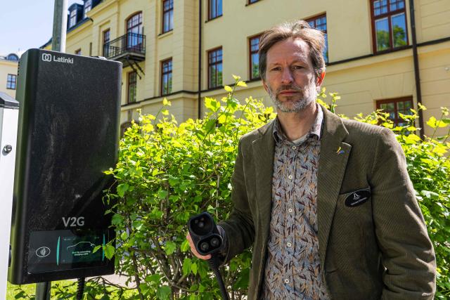 Researcher Nicholas Etherden stands beside a bi-directional Vehicle-to-Grid (V2G) charging station at the University of Gдvle on May 28, 2026 in Gдvle, Sweden. The setup is used to test Vehicle-to-Grid (V2G) technology, allowing electricity stored in the vehicle’s battery to power a building during a simulated power outage. (Photo by Jonathan NACKSTRAND / AFP)