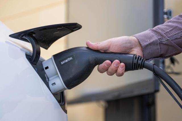 A man connects a Tesla electric vehicle to a DC/AC inverter at the University of Gдvle on May 28, 2026 in Gдvle, Sweden. The setup is used to test Vehicle-to-Grid (V2G) technology, allowing electricity stored in the vehicle’s battery to power a building during a simulated power outage. (Photo by Jonathan NACKSTRAND / AFP)